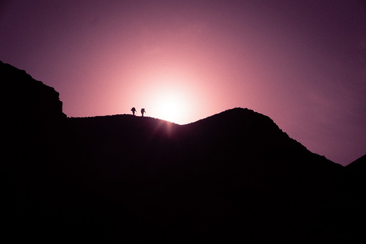silhouette photo two people on black mountain