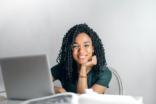 smiling woman sitting in front of laptop