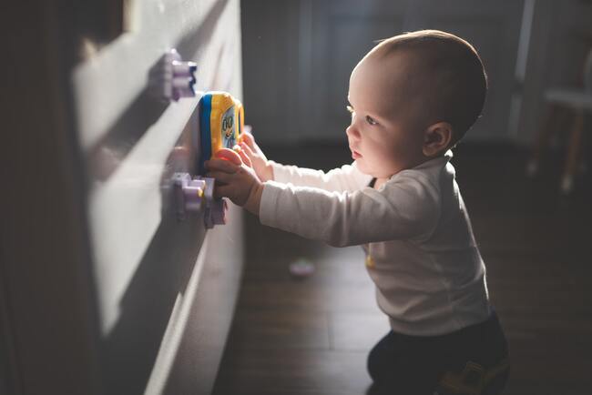 Baby playing with magnets on a fridge