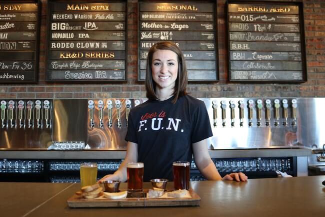 woman serving beer behind bar