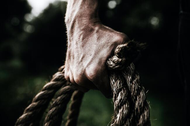strong male hand holding rope