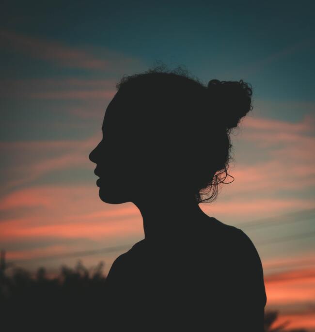 silhouette of woman with sunset behind