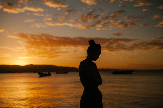 contemplative woman sunset behind