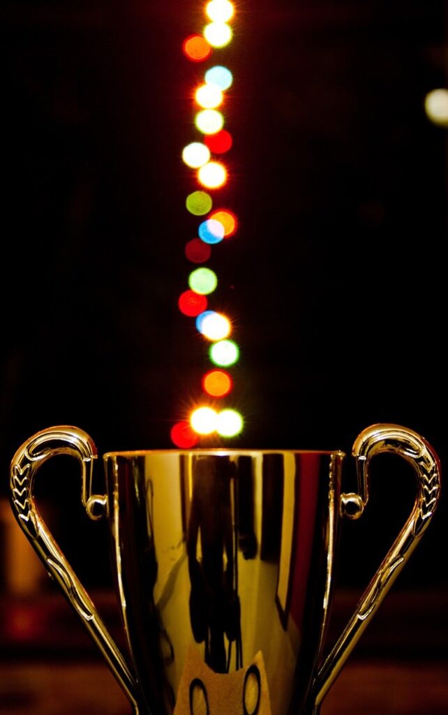 gold award cup with lights behind