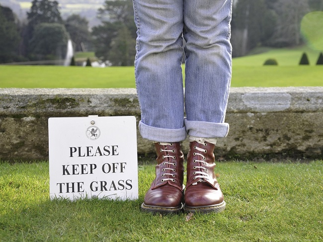 please keep off grass sign plus person standing on grass