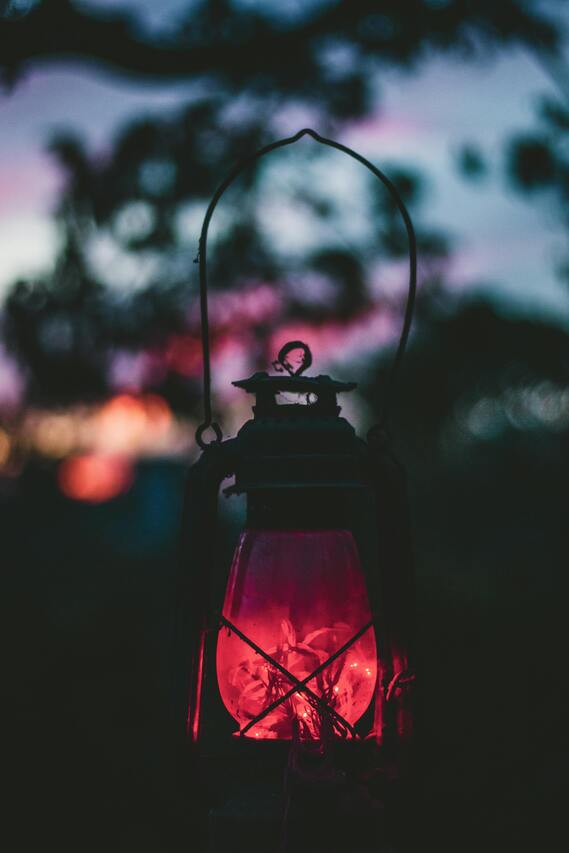 lantern with red light in front of sunset